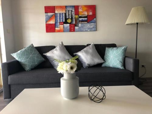 a living room with a couch and a table with flowers at Modern 2BR Apartment and Parking in Griffith - Hosted by Canstay in Kingston 