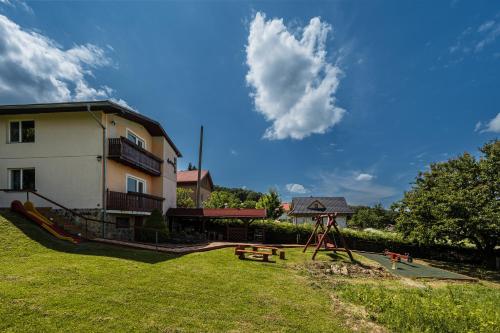 a park with a playground and a building with a sky at Apartmány MOKO in Podhájska