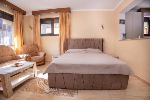 a bedroom with a bed and a couch and a table at Walter Home Bușteni with Private Terrace in Buşteni
