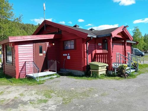 a red house with a car parked in front of it at Nordnes Kro og Camping in Rokland
