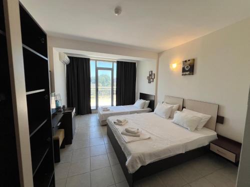 a hotel room with two beds and a desk at Persani Sunny Beach in Sunny Beach