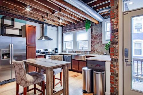 a kitchen with a wooden table and a brick wall at Inviting 3-Lvl DC Townhome Walk to METRO Station & Union Market H Street NoMa Union Station in Washington, D.C.
