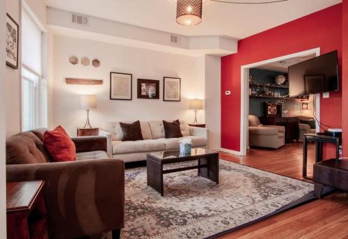 a living room with a couch and a red wall at Inviting 3-Lvl DC Townhome Walk to METRO Station & Union Market H Street NoMa Union Station in Washington, D.C.