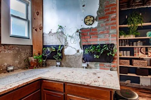 a room with a brick wall and a counter with plants at Inviting 3-Lvl DC Townhome Walk to METRO Station & Union Market H Street NoMa Union Station in Washington, D.C.