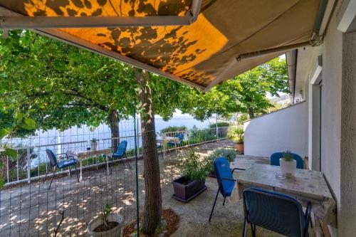 a patio with a table and chairs and a fence at Vila DADA 2 in Senj