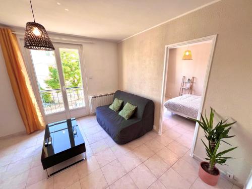 un salon avec un canapé et une table dans l'établissement Charmant T2 de 42m2 calme tout équipé Parking gratuit, à Nîmes