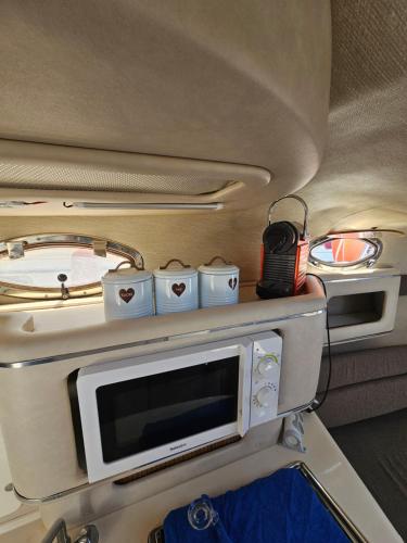 een kamer met een magnetron en een tv in een trein bij Bateau B Canet in Canet-en-Roussillon