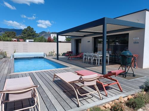 une terrasse avec une piscine, des chaises et un grill dans l'établissement Villa Posidonie, 5 pers, clim et piscine chauffée, à Lecci