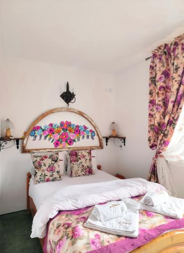 a bedroom with a bed with a floral headboard at Willa u Steni in Gliczarów