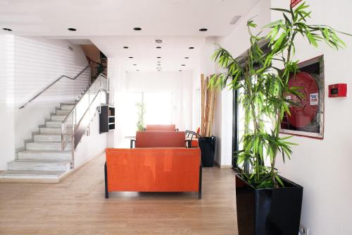 an office with a staircase and a orange chair at Hotel Cim Valles in Santa Perpetua de Moguda