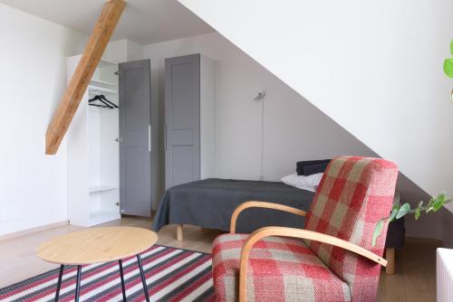 a bedroom with a bed and a chair and a table at Pühajärve tee Kodu in Otepää