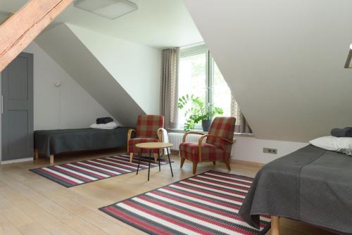 a bedroom with a bed and two chairs and a table at Pühajärve tee Kodu in Otepää