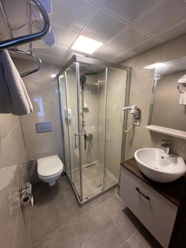 a bathroom with a shower and a toilet and a sink at Loost Town Inn Hotel in Antalya