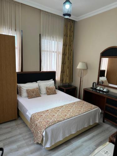 a bedroom with a large bed and a mirror at Loost Town Inn Hotel in Antalya