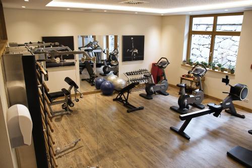 a gym with several treadmills and exercise machines at Hotel Post in Kaltenbach