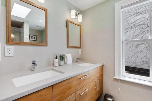 a bathroom with a sink and a mirror and a window at Historic & Modern Capitol Hill 2-BR Row Home in Washington, D.C.