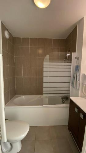 une salle de bain avec une baignoire, des toilettes et un lavabo dans l'établissement Appartement T3 avec piscine en résidence 4 étoiles, à Bénodet
