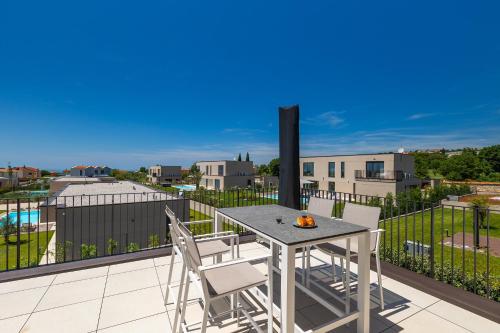 a patio with a table and chairs on a balcony at Beautiful Villa Vegt with pool in Labinci in Labinci