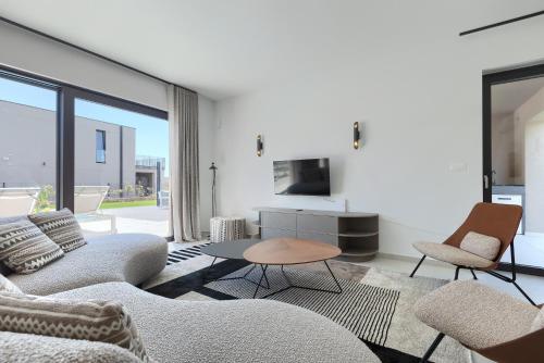 a living room with a couch and chairs and a tv at Beautiful Villa Vegt with pool in Labinci in Labinci