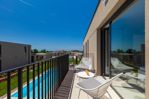 a balcony with chairs and a swimming pool at Beautiful Villa Vegt with pool in Labinci in Labinci