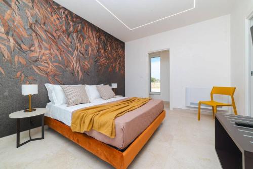 a bedroom with a bed with a painting on the wall at Villa Donnosanto a 5 minuti dalla spiaggia, Ostuni 10 minuti in Torre Santa Sabina