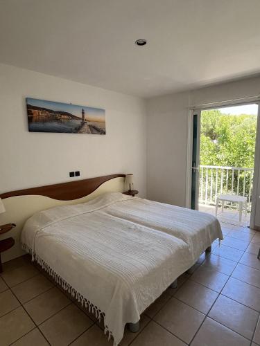 une chambre avec un lit et une grande fenêtre dans l'établissement Les Villas Maristella, Villa Goria, à Aregno