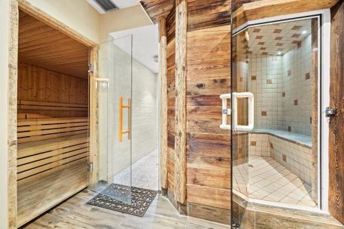 a sauna with wooden walls and a glass door at Residence Des Alpes in Cavalese