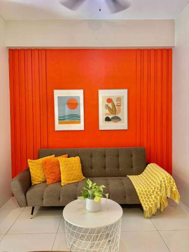 a living room with a couch against a red wall at Sunset Room at Pico - Hamilo Coast Pico De Loro in Nasugbu