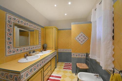 une salle de bain avec deux lavabos et un miroir dans l'établissement Monte Leon, à Châteaurenard