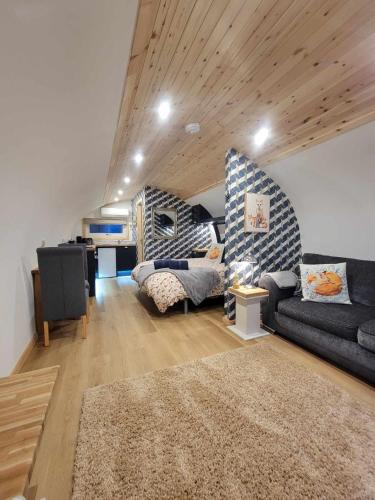a living room with a couch and a desk at The Galloway Steading - The Fox's Den with Hot Tub and Fire Pit in Glenluce