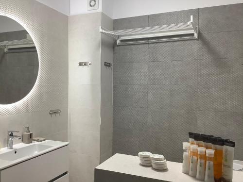 a bathroom with a sink and a toilet and a mirror at Ammos Apartment Mamaia in Mamaia