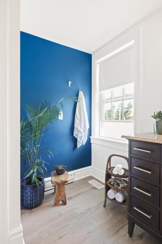 a room with a blue wall and a dresser at The Summerhouse @ Saint Peters in Saint Peters