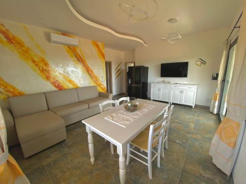 a living room with a white table and a couch at Hotel Pedra Niedda in Budoni