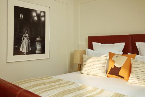 a bedroom with a bed with a picture on the wall at Hotel La Villa Saint Germain Des Prés in Paris