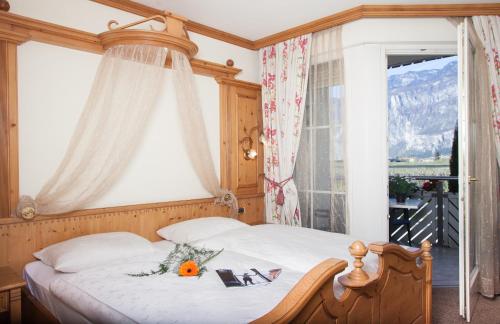 Un dormitorio con una cama y una ventana con una montaña en Hotel Comfort Erica Dolomiti Val d'Adige, en Salorno