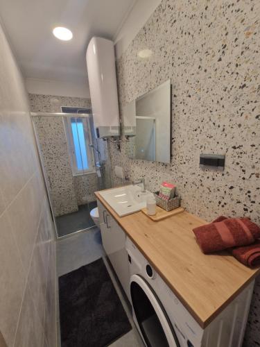 a bathroom with a sink and a mirror at Apartmani Rukavina in Rab