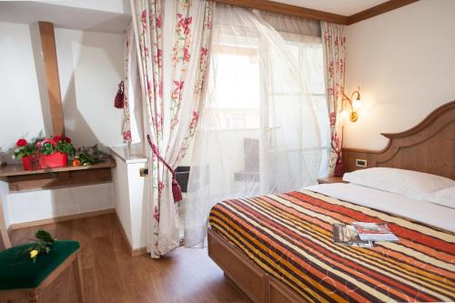 a bedroom with a bed and a window at Hotel Comfort Erica Dolomiti Val d'Adige in Salorno sulla Strada del Vino