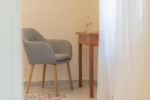 a chair sitting next to a wooden table with a desk at Lake Lovers Lodge in Montefiascone
