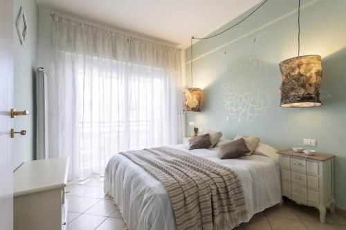 a bedroom with a bed and a window at Trilocale vista spiaggiamare in Diano Marina