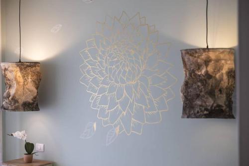 a wall with two lights and a flower on it at Trilocale vista spiaggiamare in Diano Marina