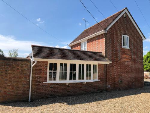 a red brick house with a white window at Stablehurst Cottage in West Hoathley