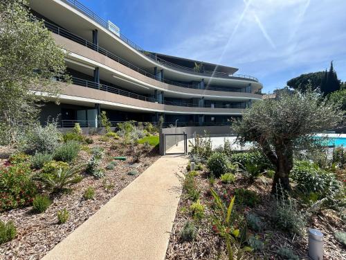 un bâtiment avec un trottoir en face d'un jardin dans l'établissement Fabron Hills, à Nice