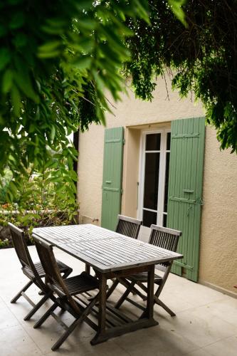 - une table de pique-nique et 2 chaises devant un bâtiment dans l'établissement O Cabanon - Superbe Villa rénovée avec piscine privée, à Laroque-des-Albères