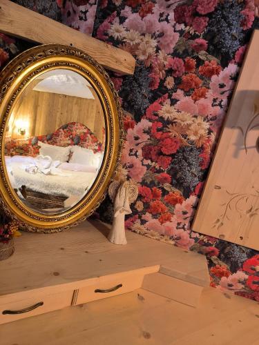 a mirror on top of a dresser next to a wall at Willa u Steni in Gliczarów