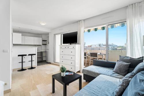 un salon avec un canapé et une cuisine dans l'établissement Studio Velasquez - Welkeys, à Cannes