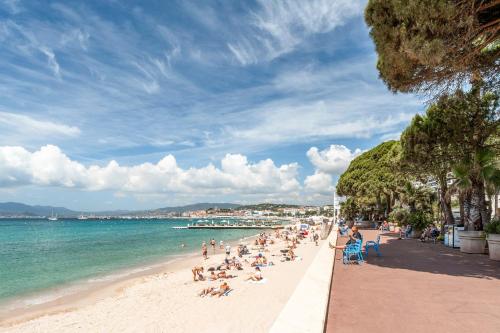 un groupe de personnes assises sur une plage dans l'établissement Studio Velasquez - Welkeys, à Cannes