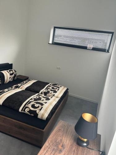 a bedroom with a bed with a lamp and a window at Apart das Ehrets mit 3 Schlafzimmer in Bretzfeld