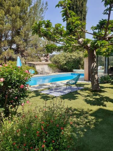 - une piscine avec un banc dans la cour dans l'établissement Belle villa avec piscine proche d Aix en provence, à Cabriès