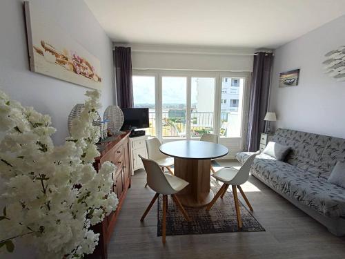 un salon avec une table, des chaises et un canapé dans l'établissement Appartement rénové avec terrasse à 200m des plages à Trégastel - FR-1-368-122, à Trégastel