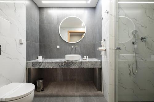 a bathroom with a sink and a mirror at Hotel Jarzębata in Wisła